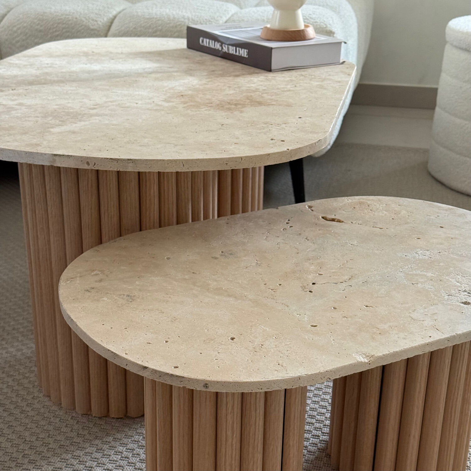Oval coffee table duo travertine and raw fluted wooden legs.