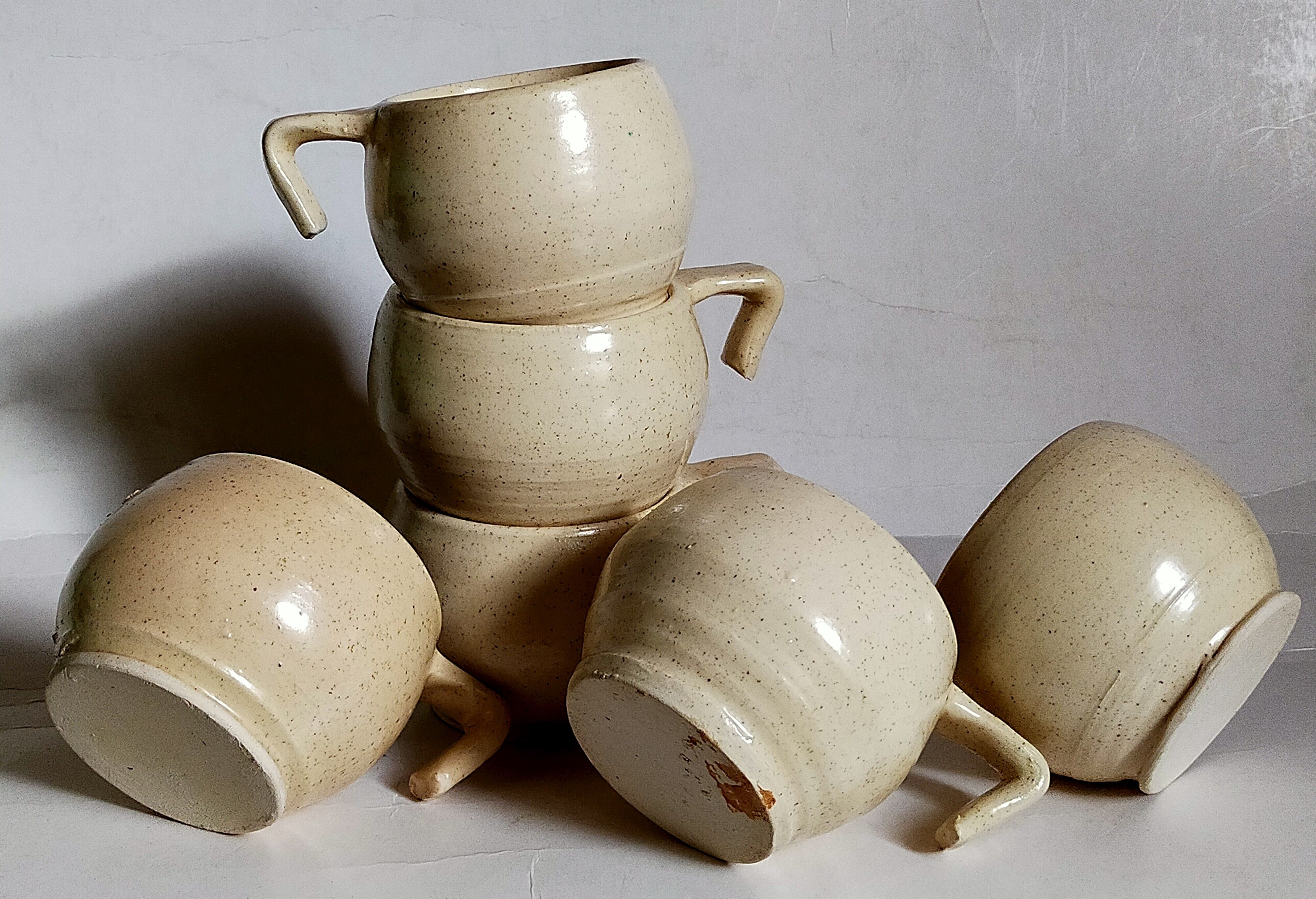 Six vintage potter's ceramic cups with vanilla enamel