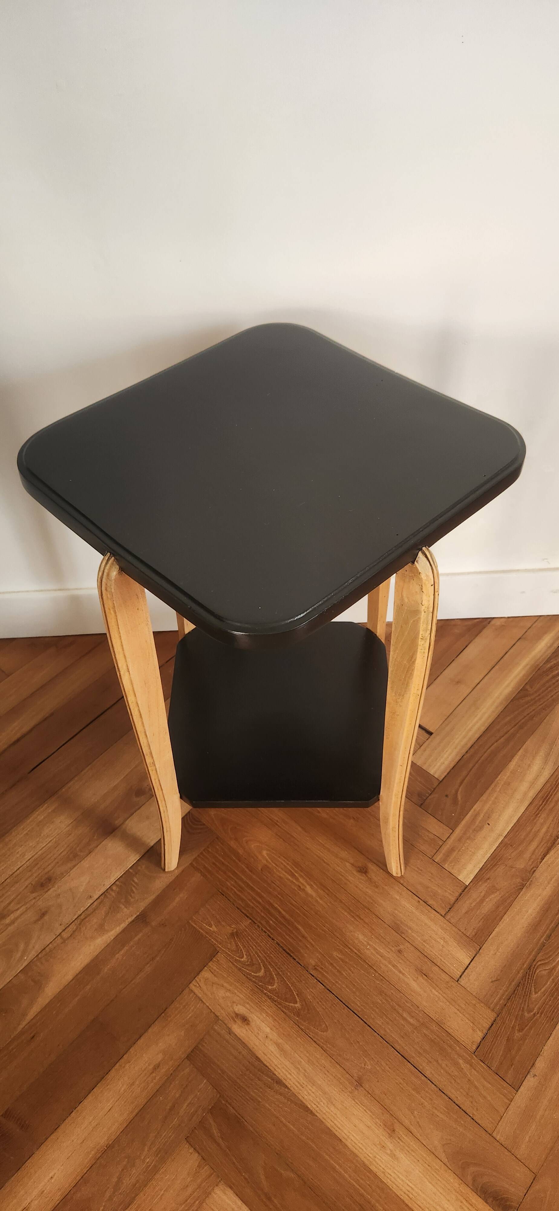 Black lacquered wooden side table with offset tops.
