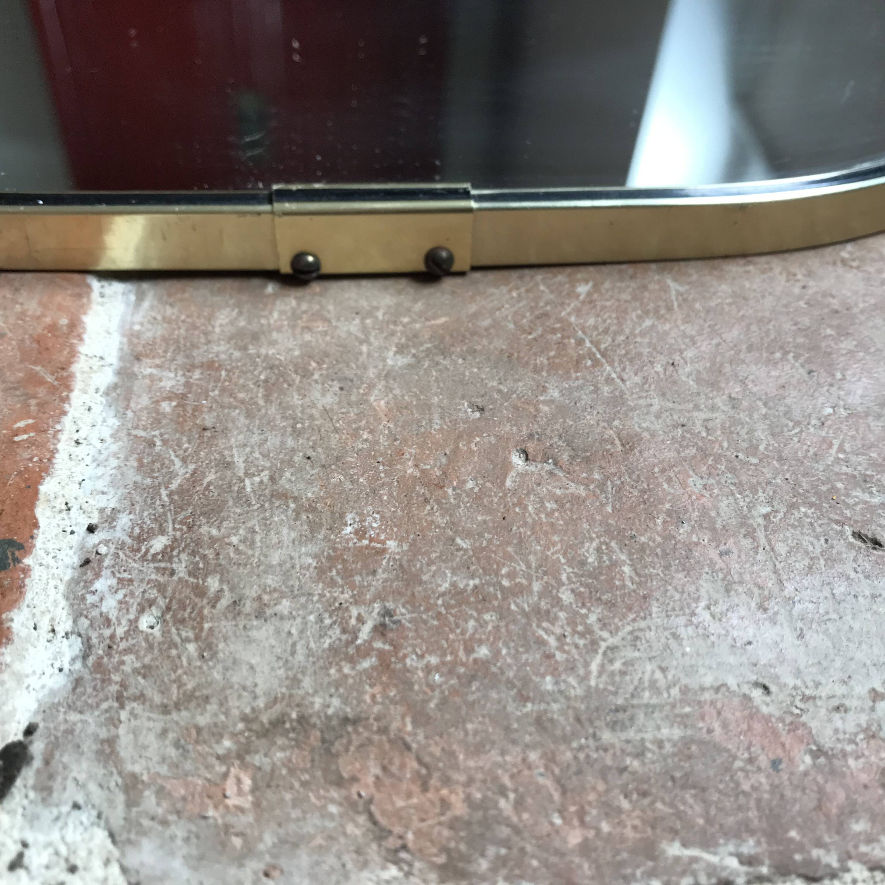 Vintage 1960 free-form mirror known as a retro mirror with a gold and black metal trim.