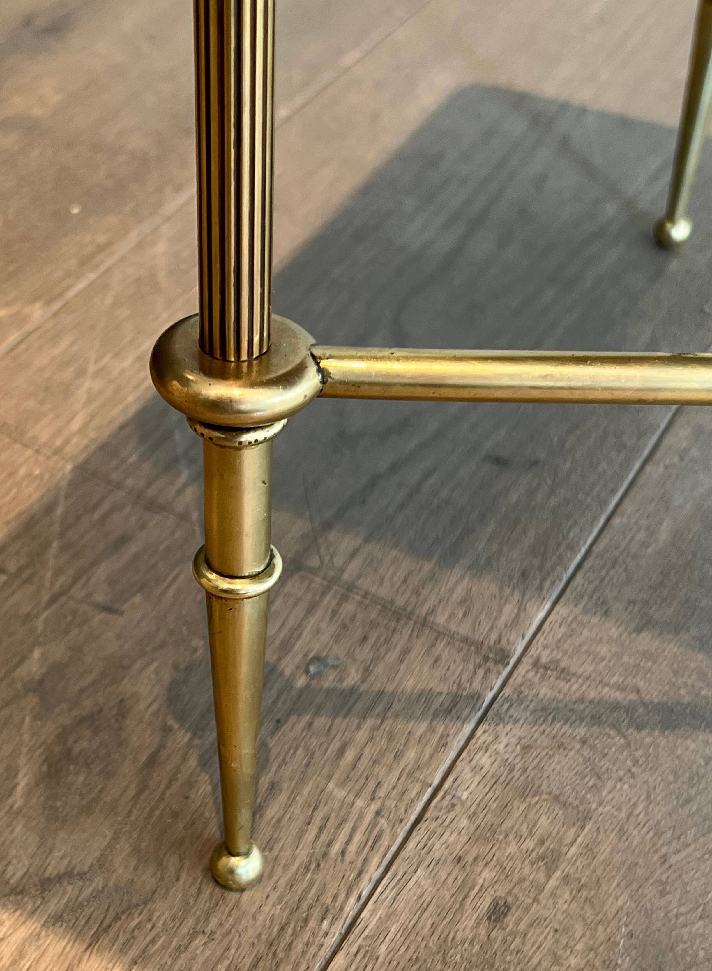 Neoclassical brass coffee table with a black leather top and golden borders from Maison Jansen.