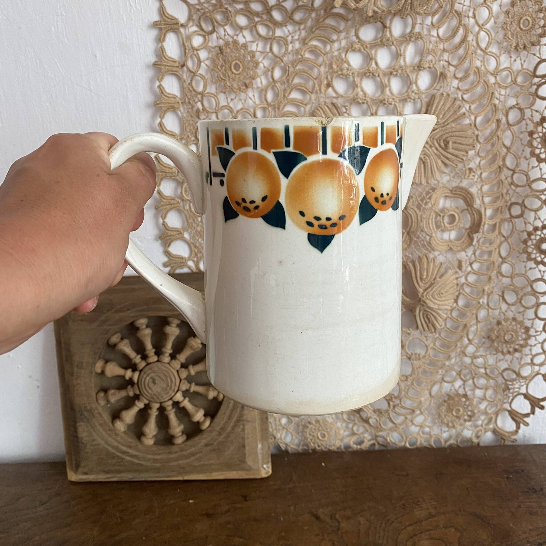 Old ceramic pitcher with orange decoration.