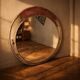 Vintage round mirror with an industrial metal frame in a painted finish.