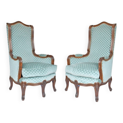 Paire de fauteuils bergères à oreilles de style Louis XV à cinq pieds