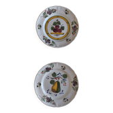 Two earthenware plates with fruits, pears and plums.