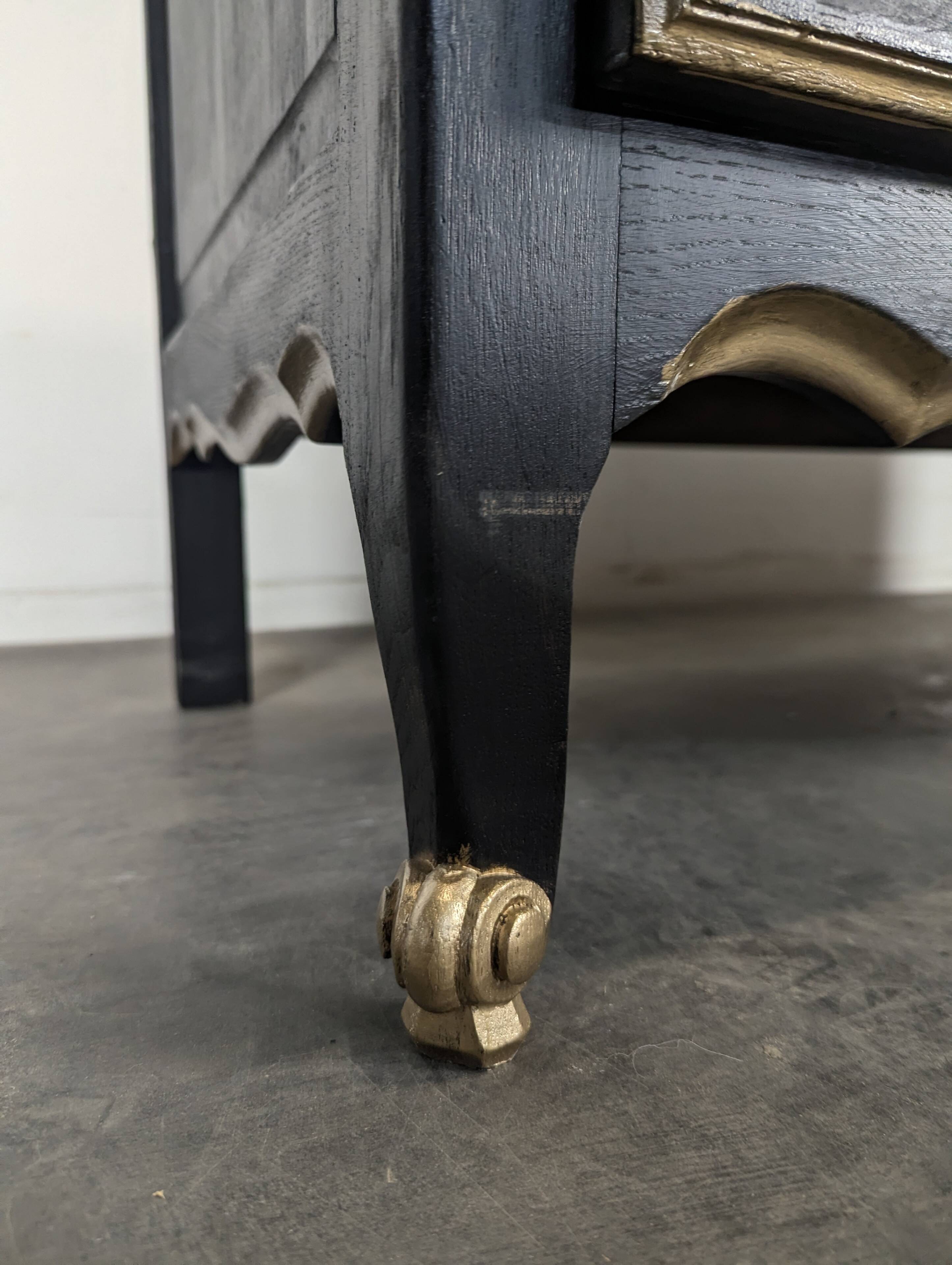 Commode de style Louis XV en chêne laqué noir et rechampi or