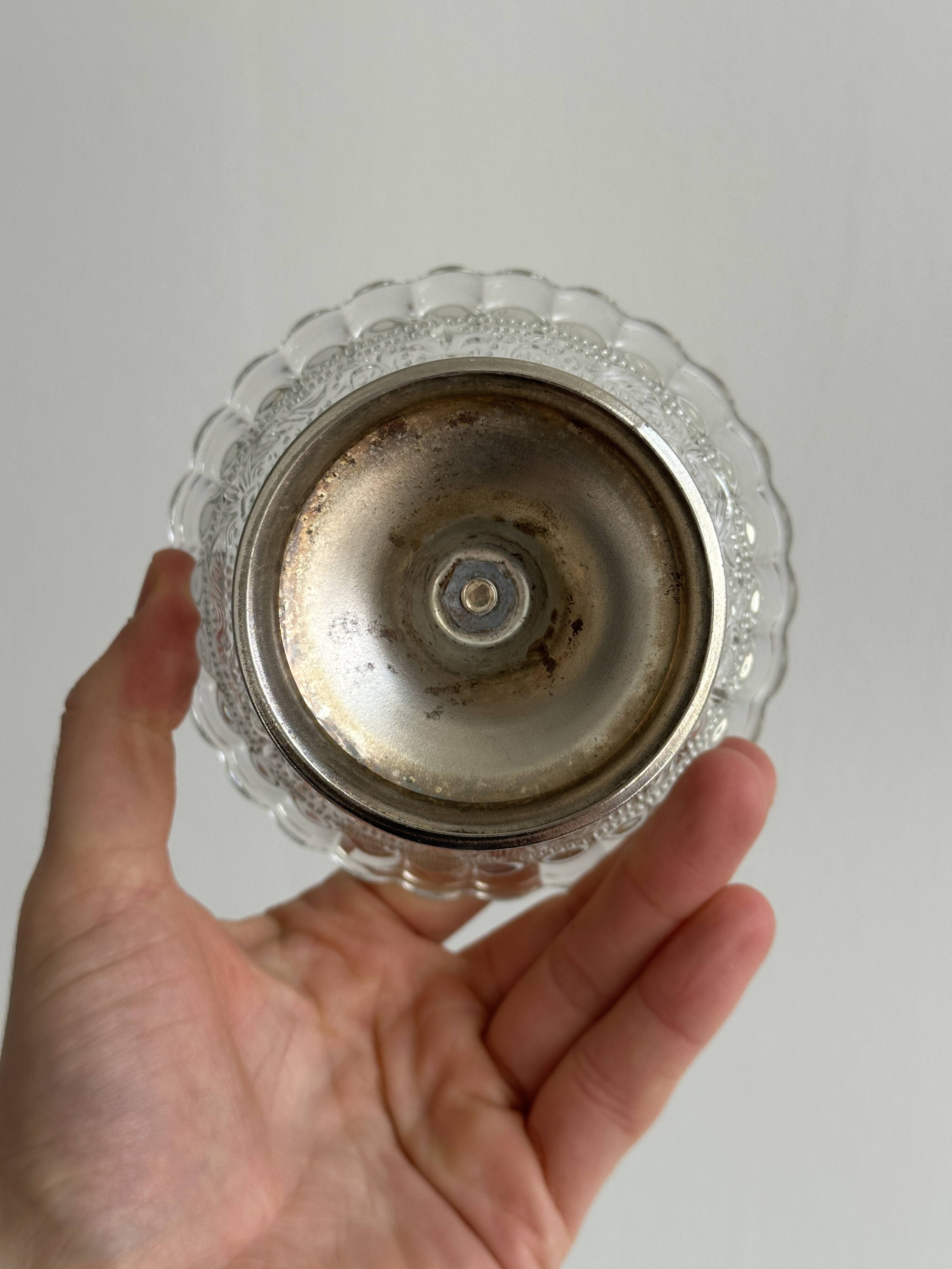 Thick glass bowl on a metal stand.