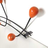 Black metal coat rack and orange wood balls