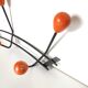 Black metal coat rack and orange wood balls