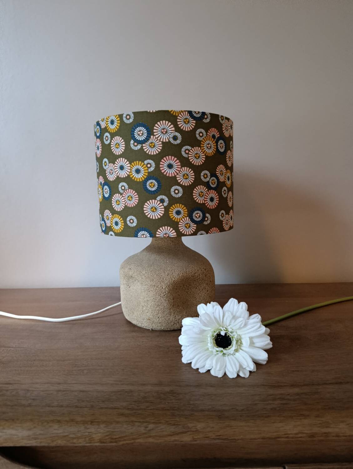 Table lamp with light green onyx base, fabric shade with a khaki background.