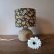 Table lamp with light green onyx base, fabric shade with a khaki background.