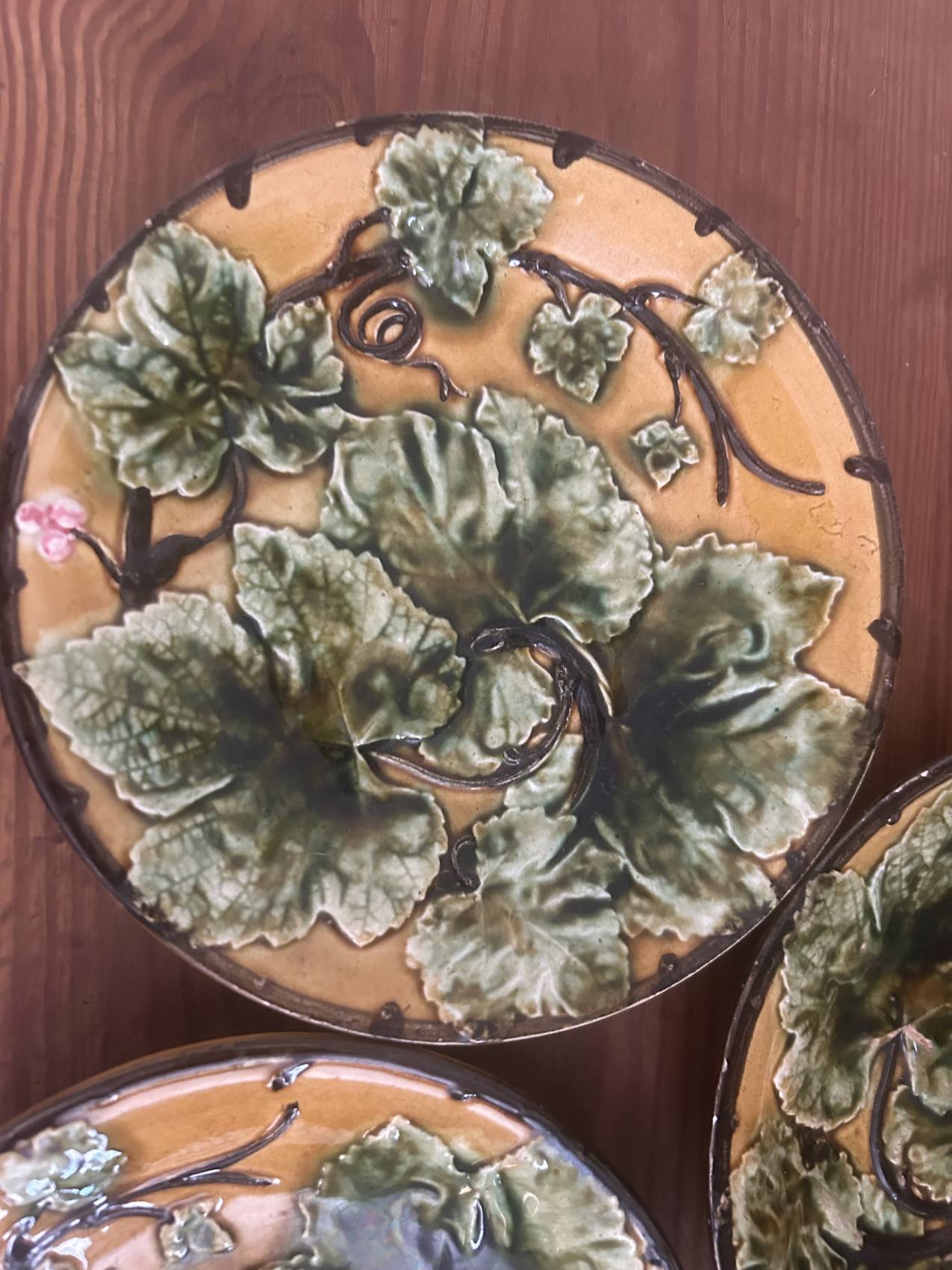 Four antique dessert plates in majolica with vine decoration.