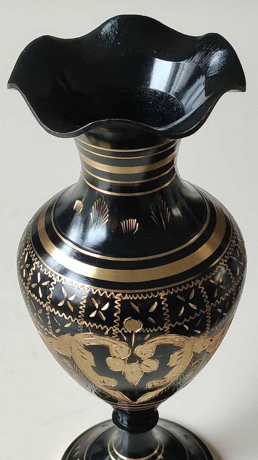 Vintage brass vase with black and gold patina, corolla neck. From India. Mid-20th century. Engraved heart/floral/leafy patterns. High 20 cm