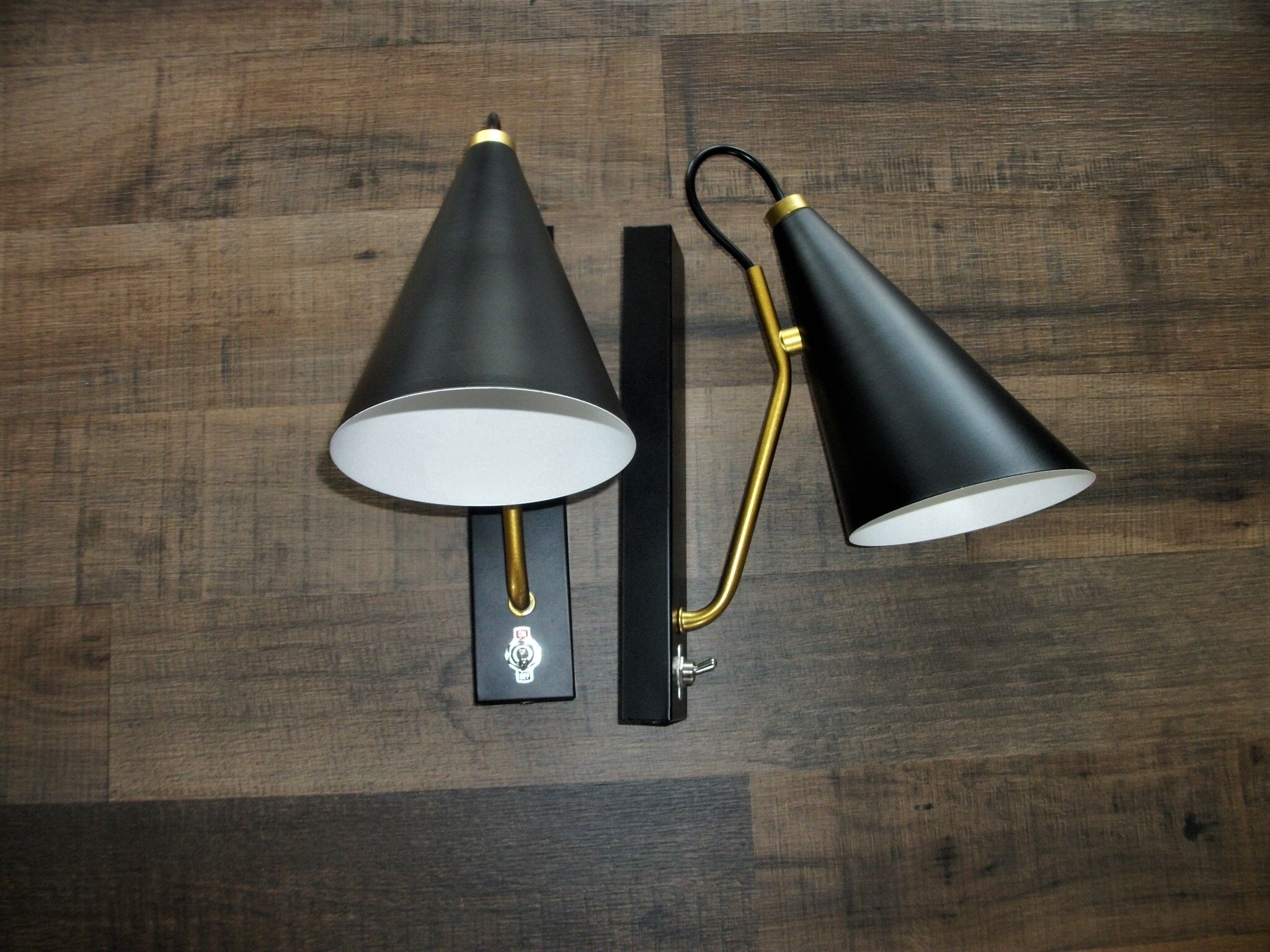 Pair of modernist sconces in black and gold metal