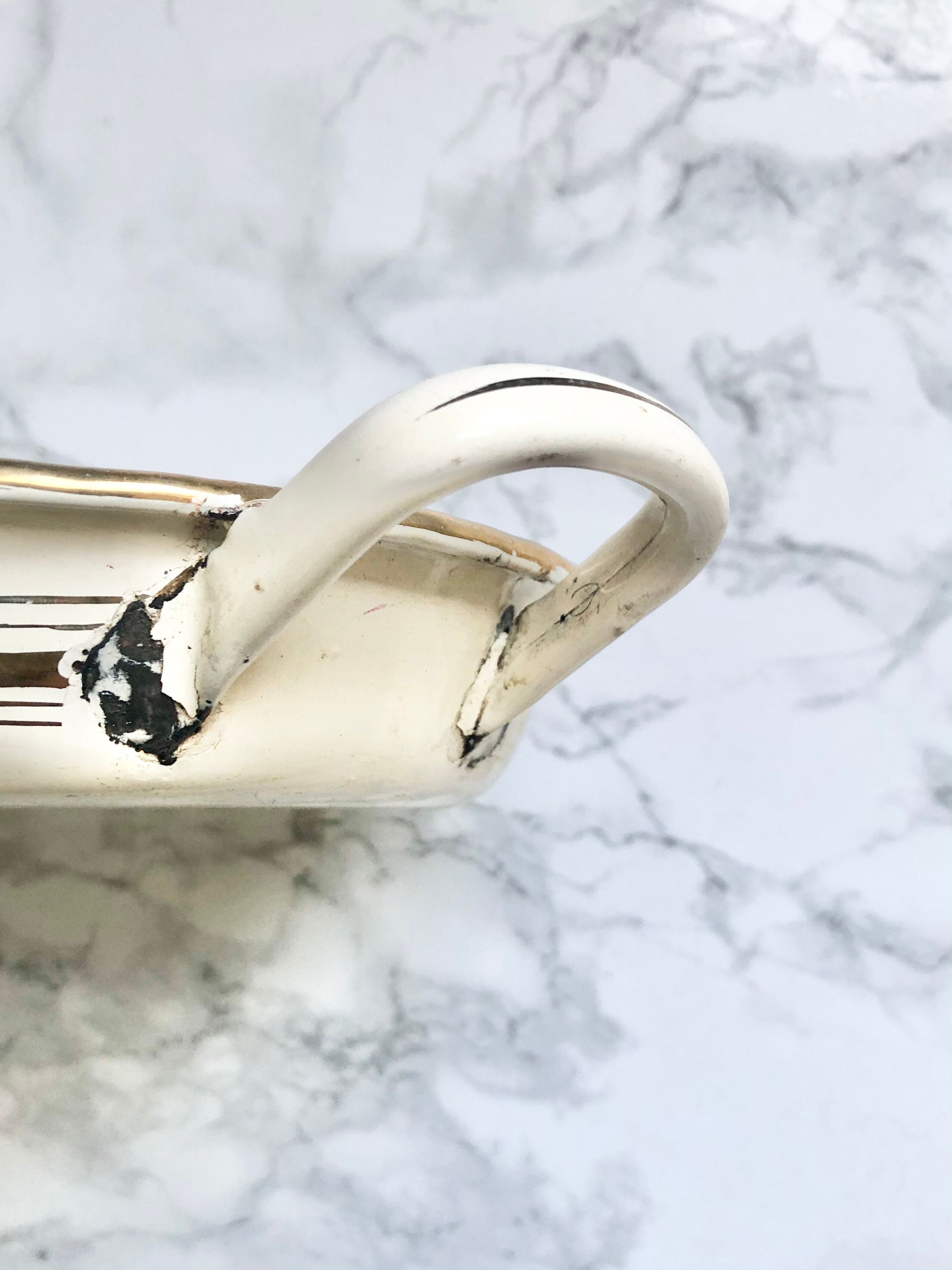 Old egg dish in creamy white and golden enamelled sheet