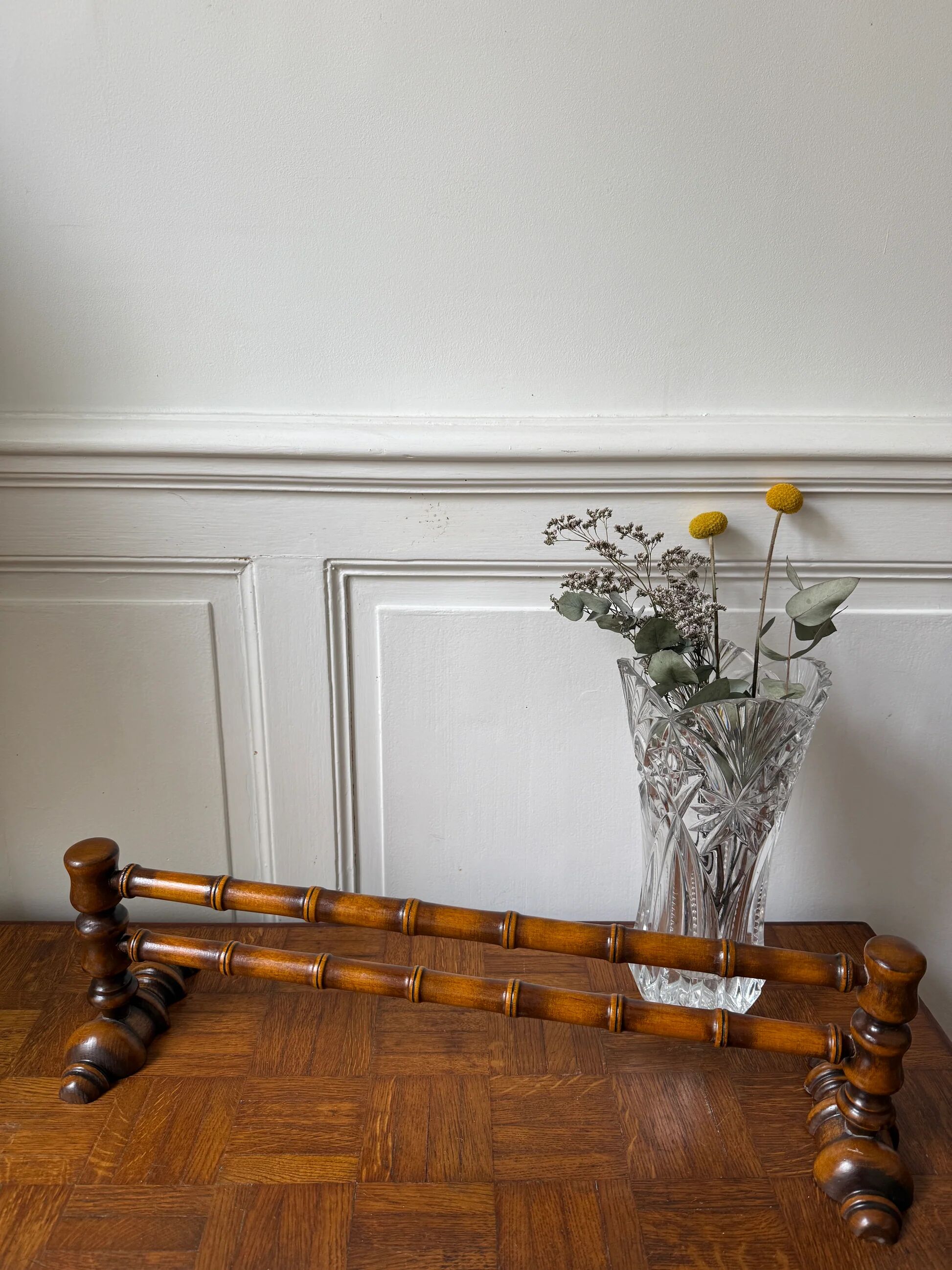 Wall-mounted coat rack made of turned wood in a bamboo style.