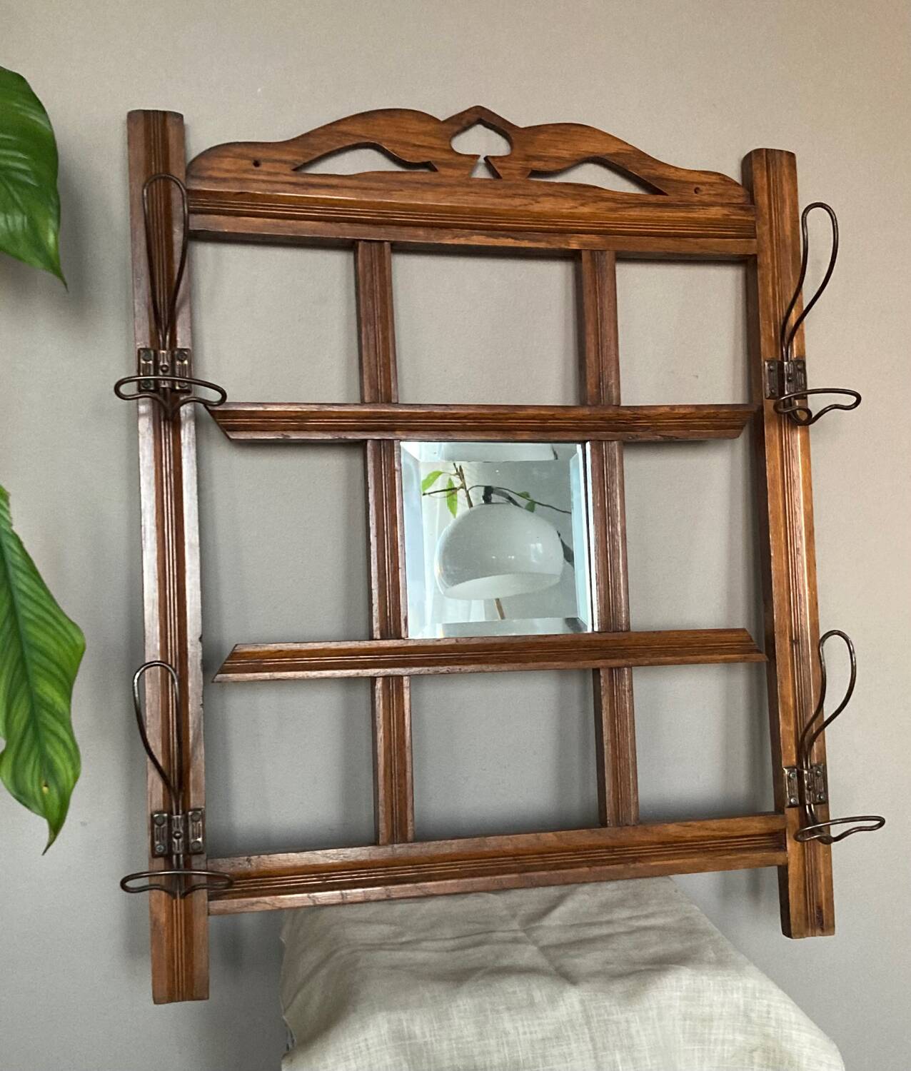 Art Deco wall-mounted coat rack in oak, early 20th century. Beveled central mirror