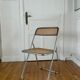 Vintage folding chair in metal and cane.