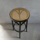 Curved wooden bar stool with a caned seat.