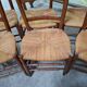 Set of six rustic chairs in natural wood with straw seats.
