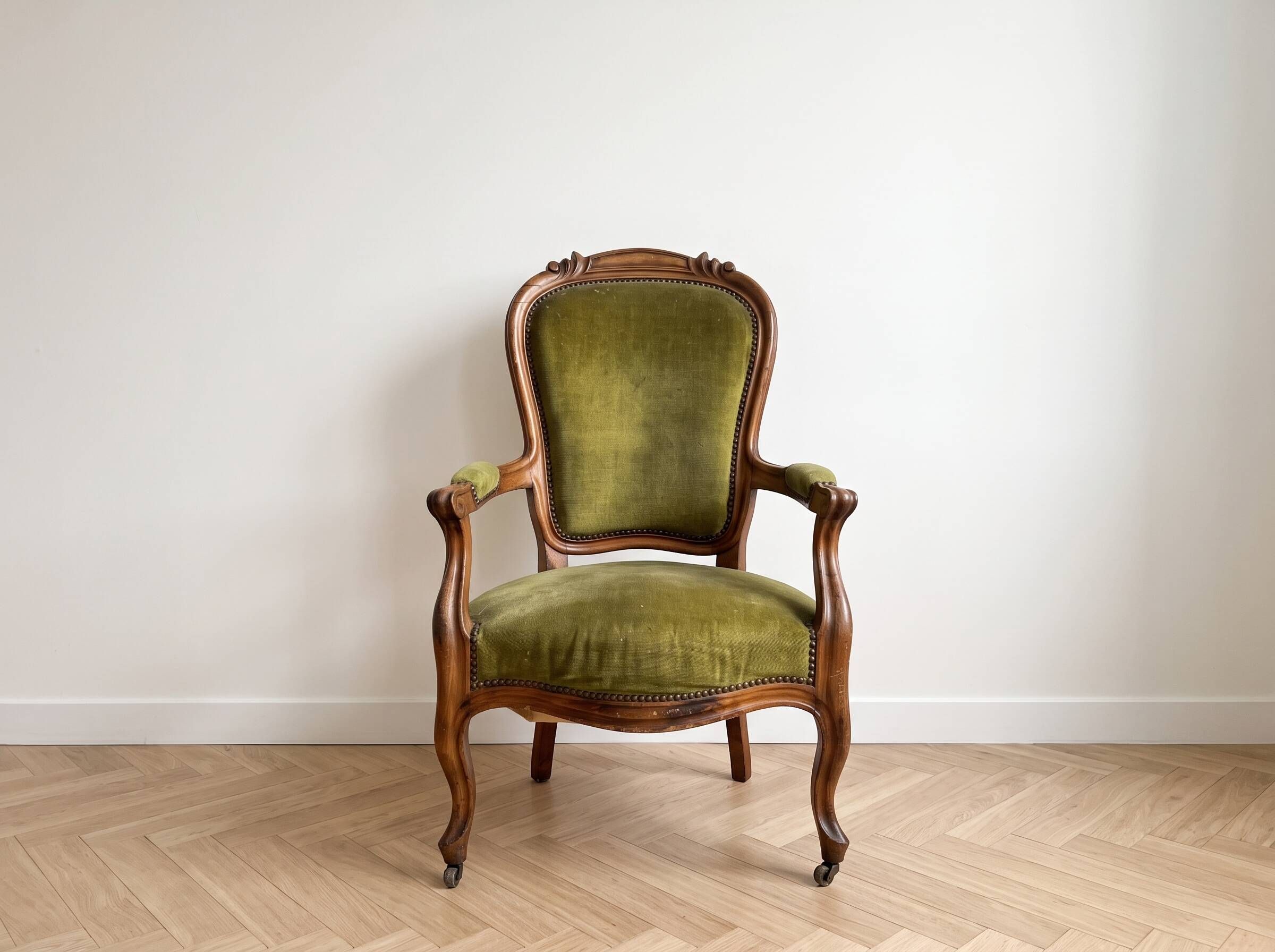 Antique armchair in olive green velvet and carved wood.