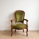 Antique armchair in olive green velvet and carved wood.