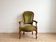 Antique armchair in olive green velvet and carved wood.