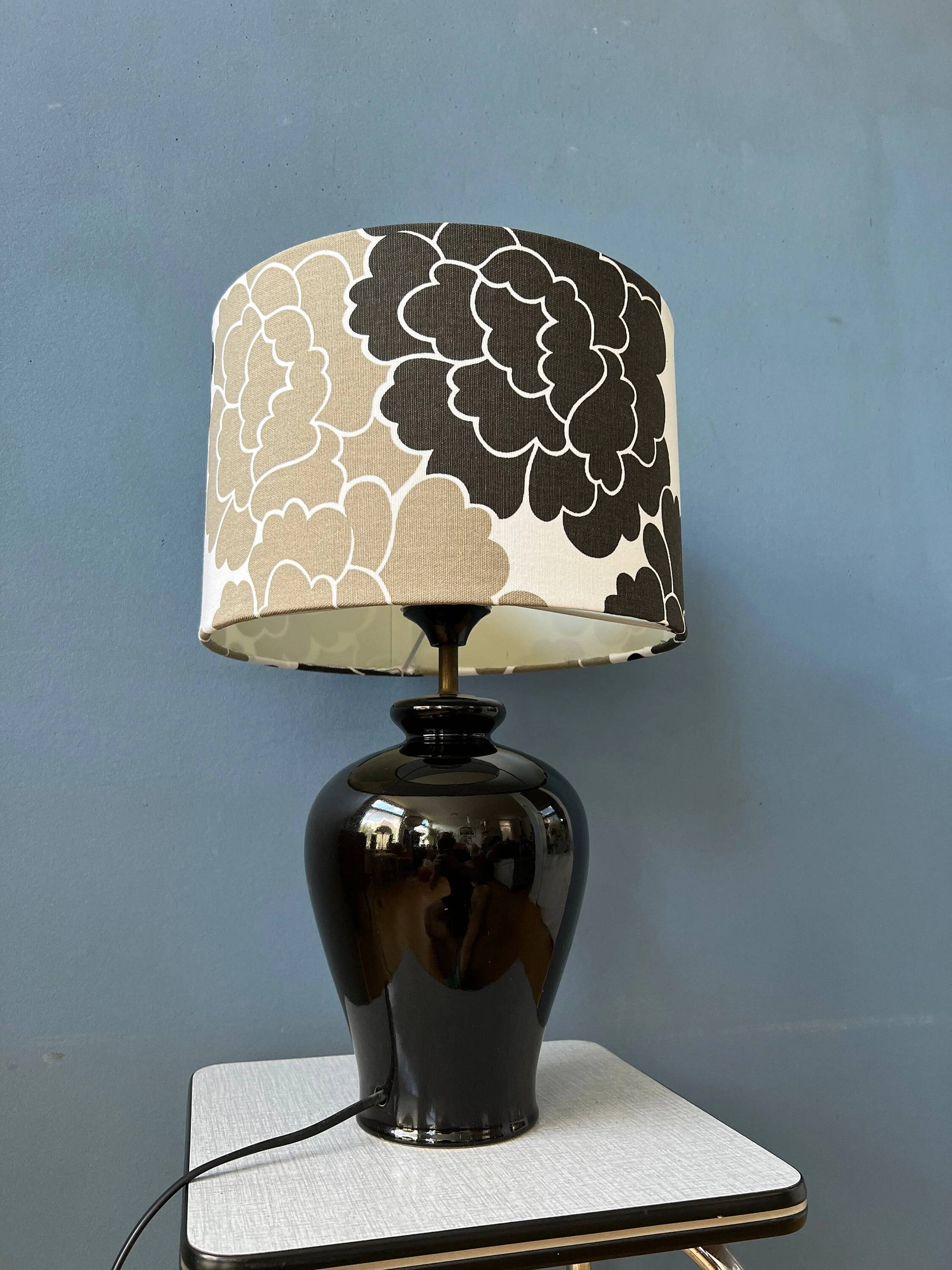 Small Space Age table lamp with a porcelain base and black and white flower shade.