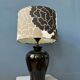 Small Space Age table lamp with a porcelain base and black and white flower shade.