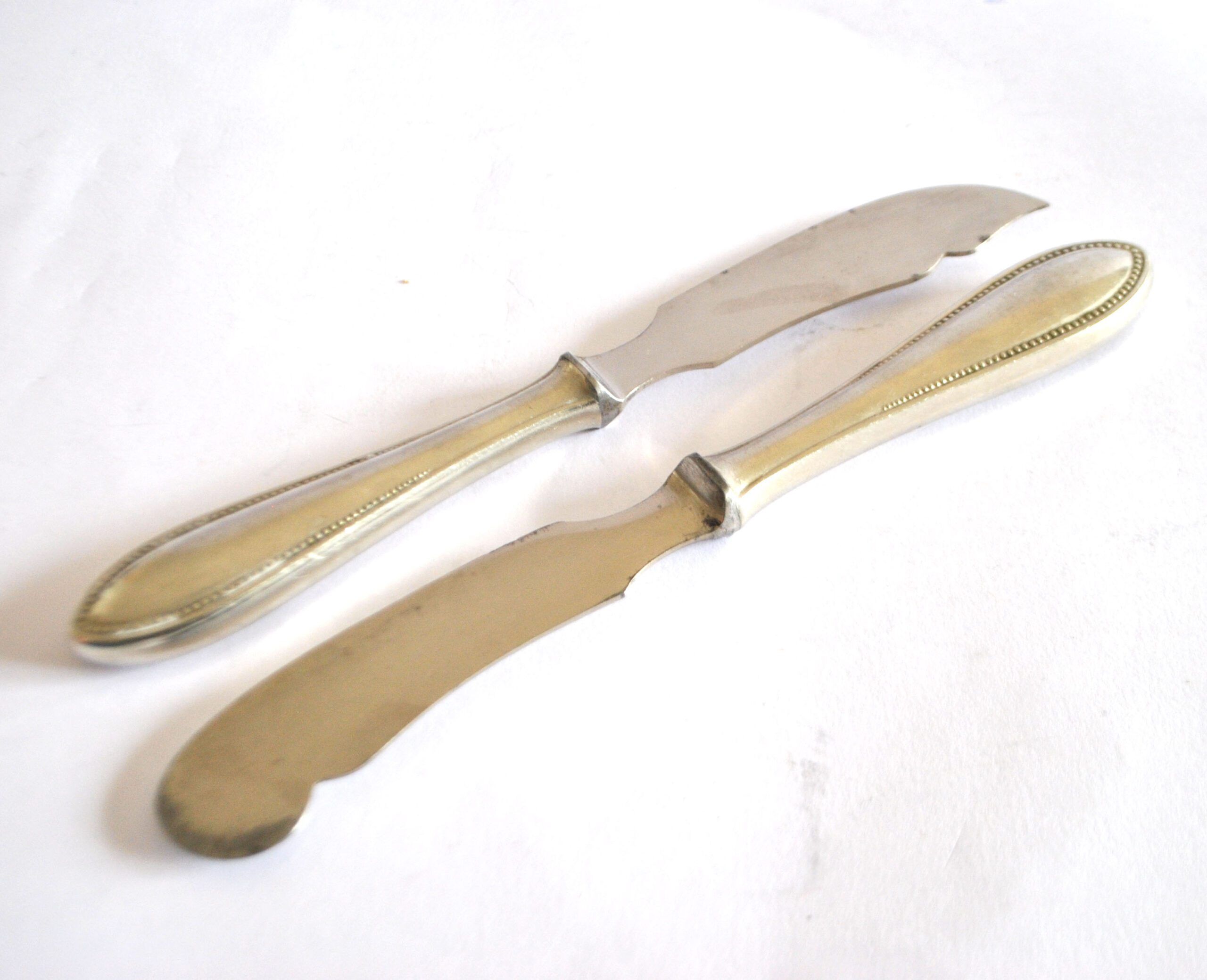 Two antique service knives in silver-plated metal, pearl frieze gowe alpacca.
