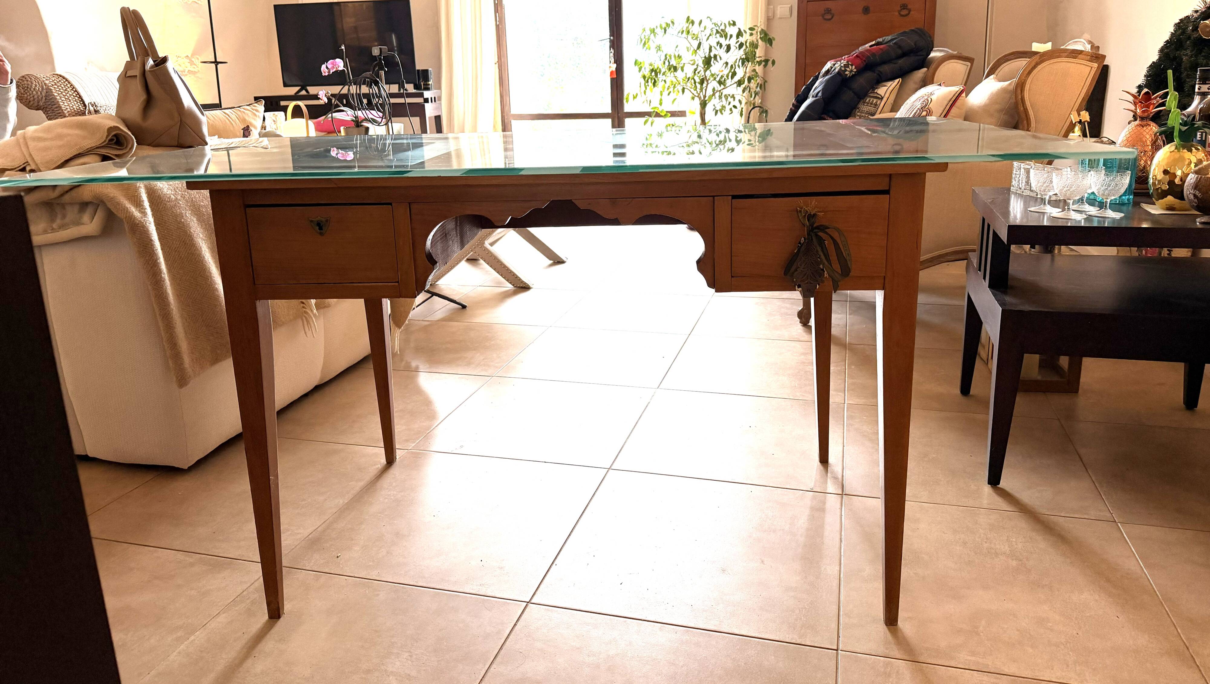 Elegant antique desk in cherry wood with a black leather top and glass plate.