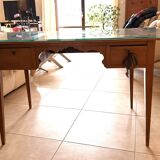 Elegant antique desk in cherry wood with a black leather top and glass plate.