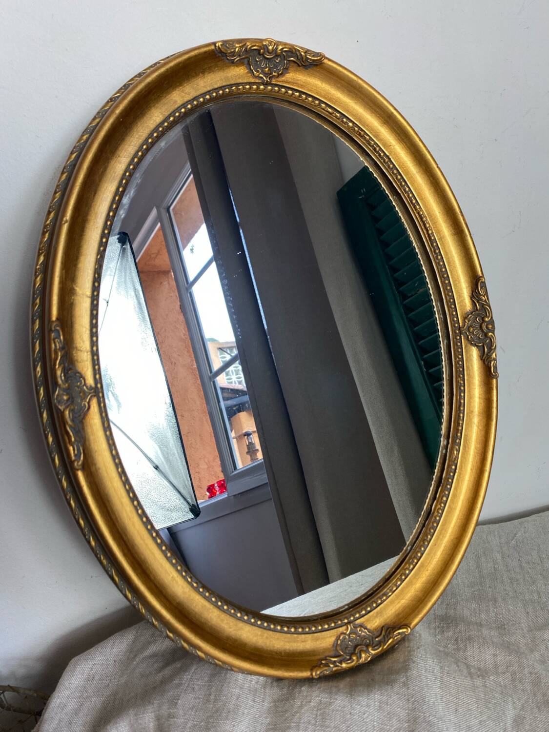 Oval-shaped gilded wooden mirror