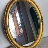 Oval-shaped gilded wooden mirror