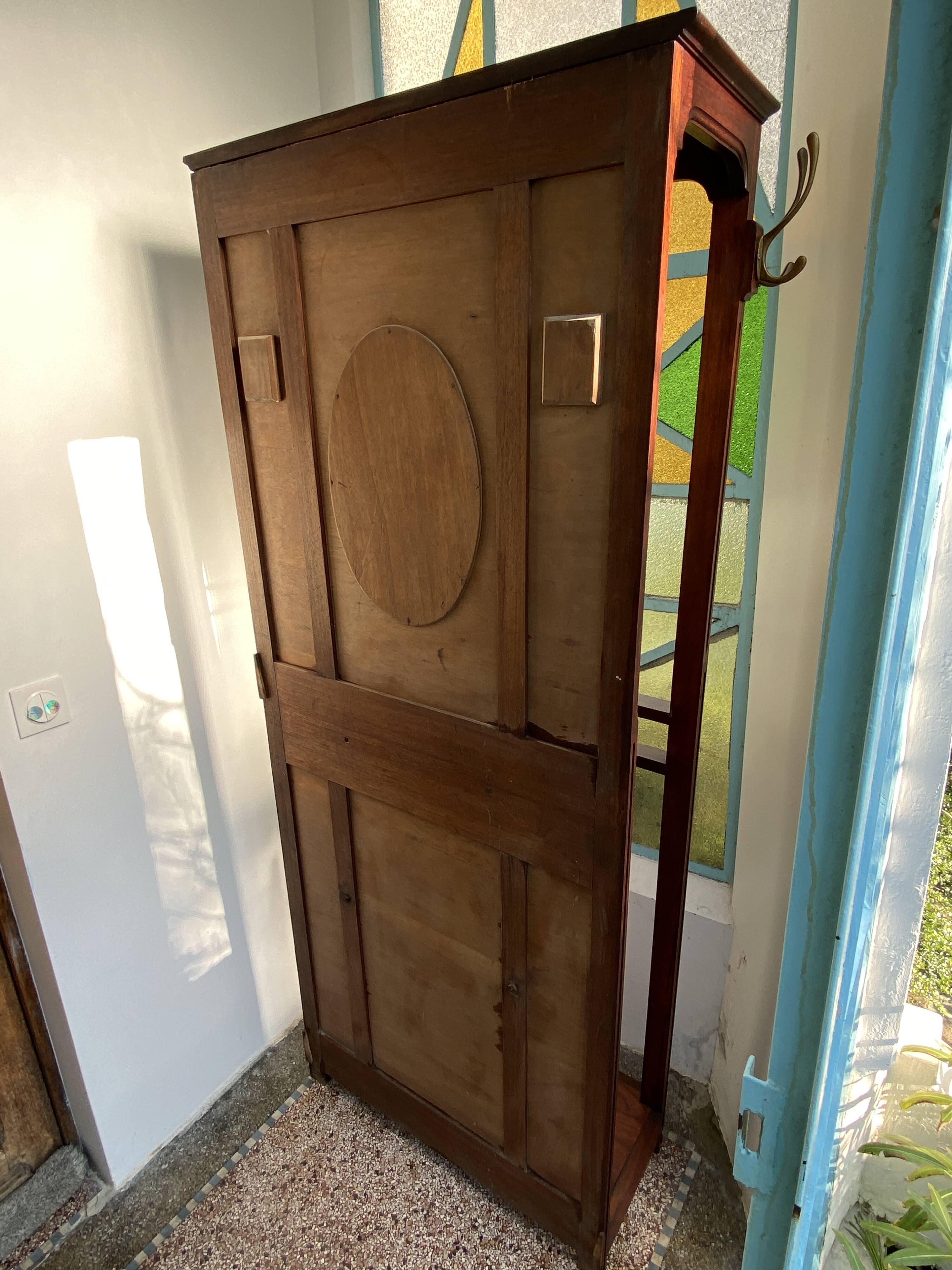 Antique wooden coat rack with mirror and shelf.