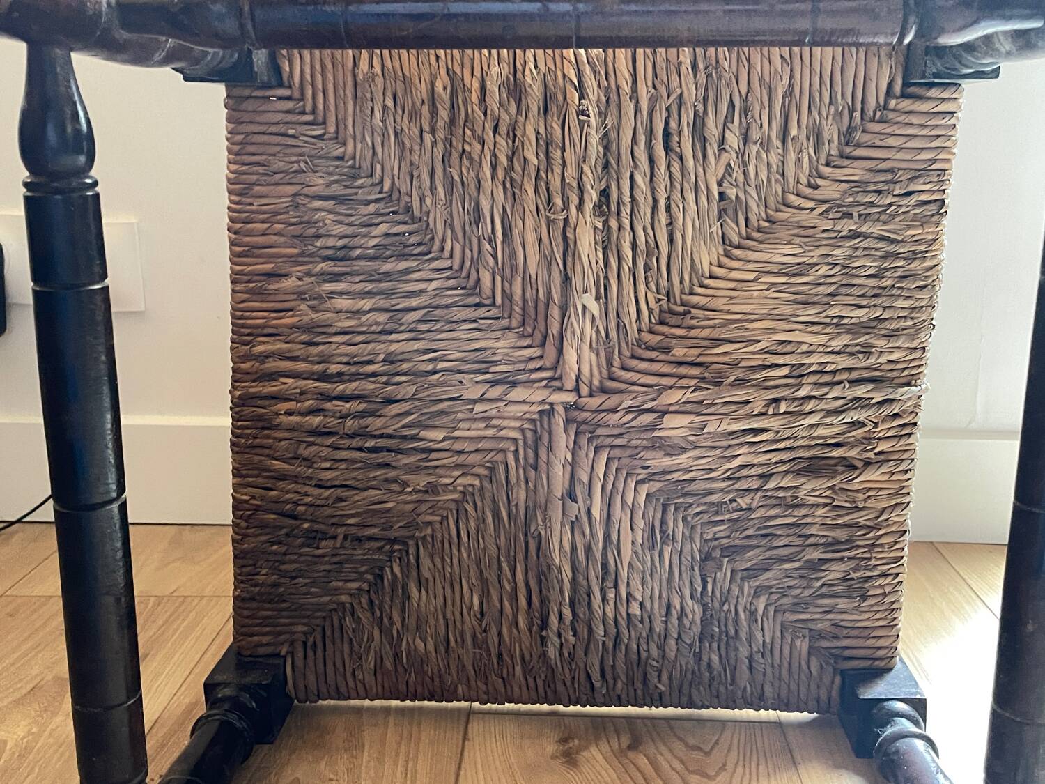 Corner chair made of turned wood with a straw seat.