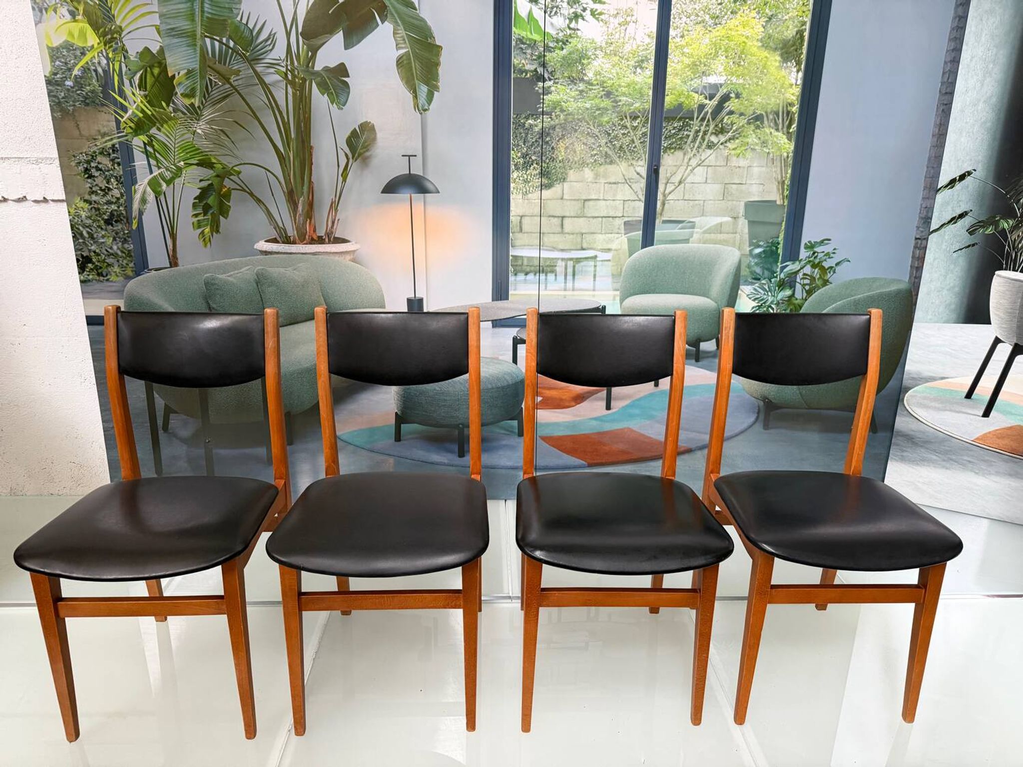 4 Scandinavian chairs in teak and black faux leather.