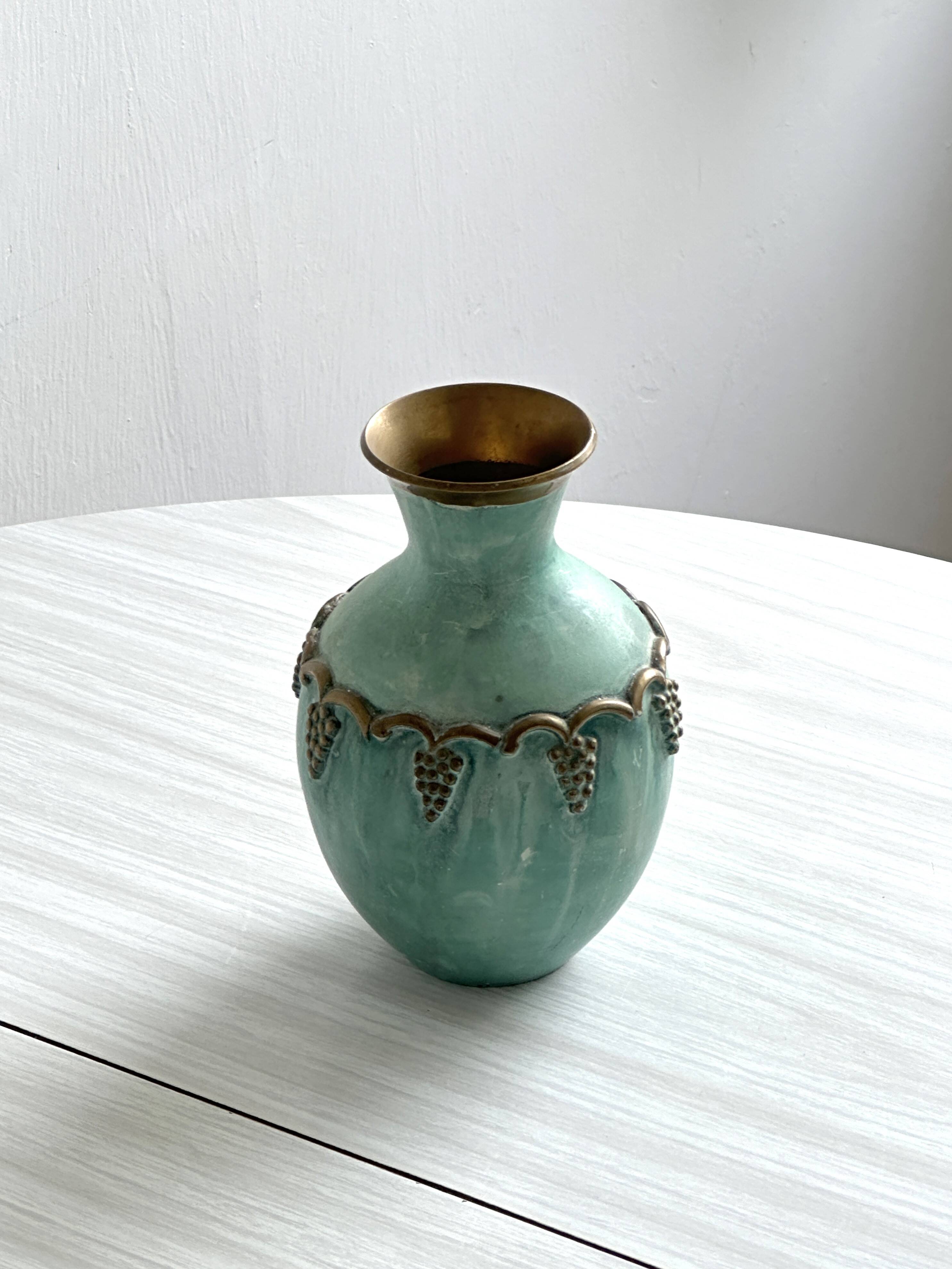 Brass vase decorated with bunches of grapes.