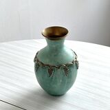 Brass vase decorated with bunches of grapes.