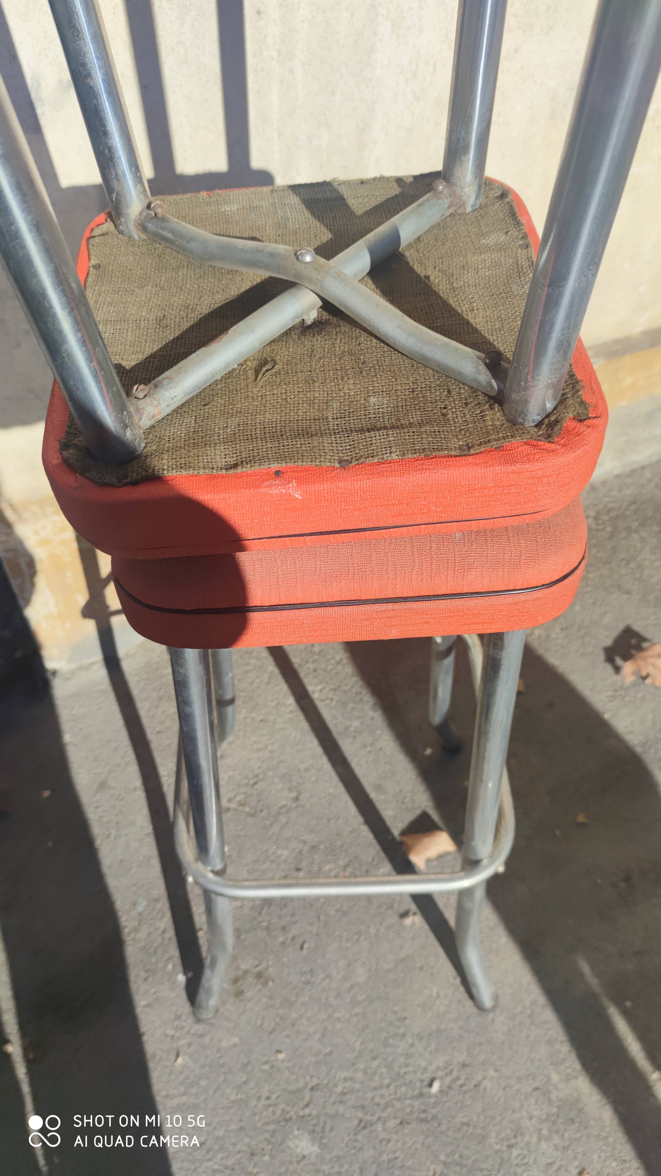 Pair of aluminum bar stools with orange and black seats
