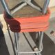 Pair of aluminum bar stools with orange and black seats