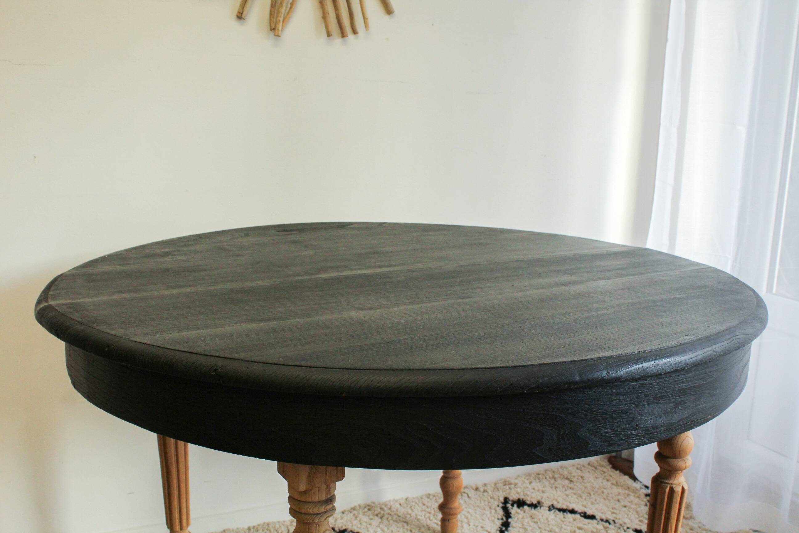 Round black dining table with oak wood.