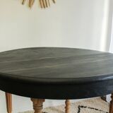 Round black dining table with oak wood.