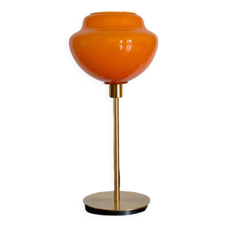 Table lamp with an old globe in vintage orange opaline