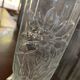 Transparent glass vase with relief floral decoration from the 1980s, fluted neck and polygonal base.
