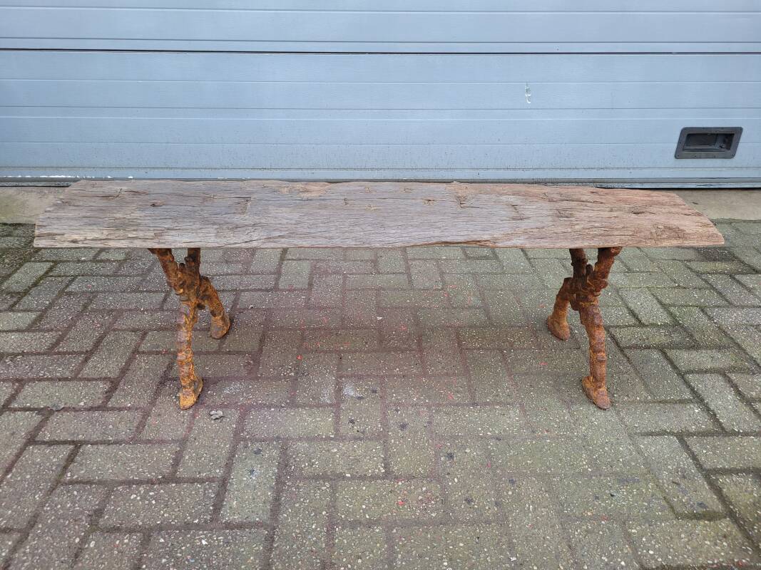 French country style cast iron bench with old rustic wooden plank