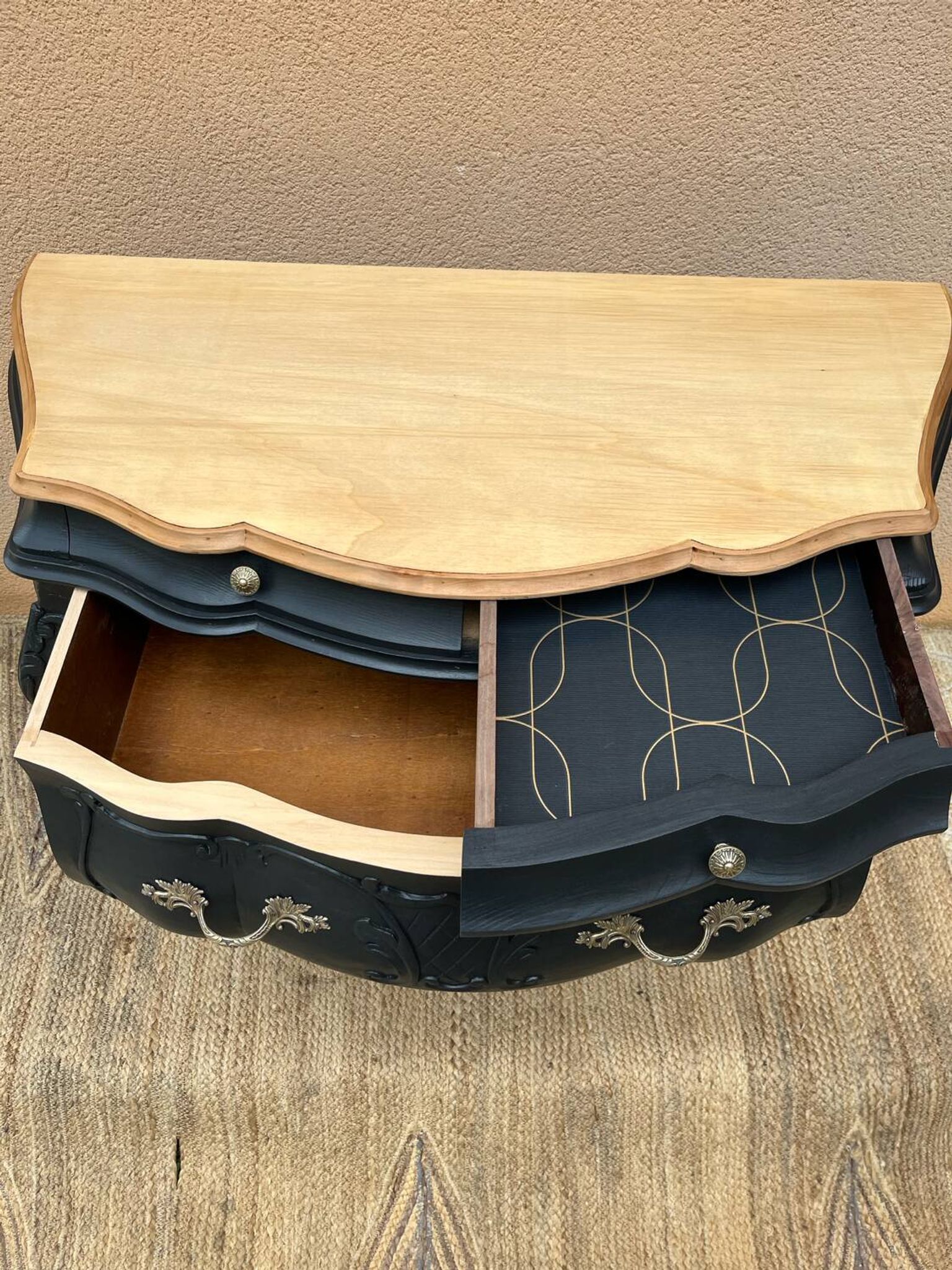 Commode galbée peinte en noir et bois