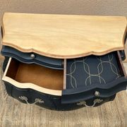Commode galbée peinte en noir et bois