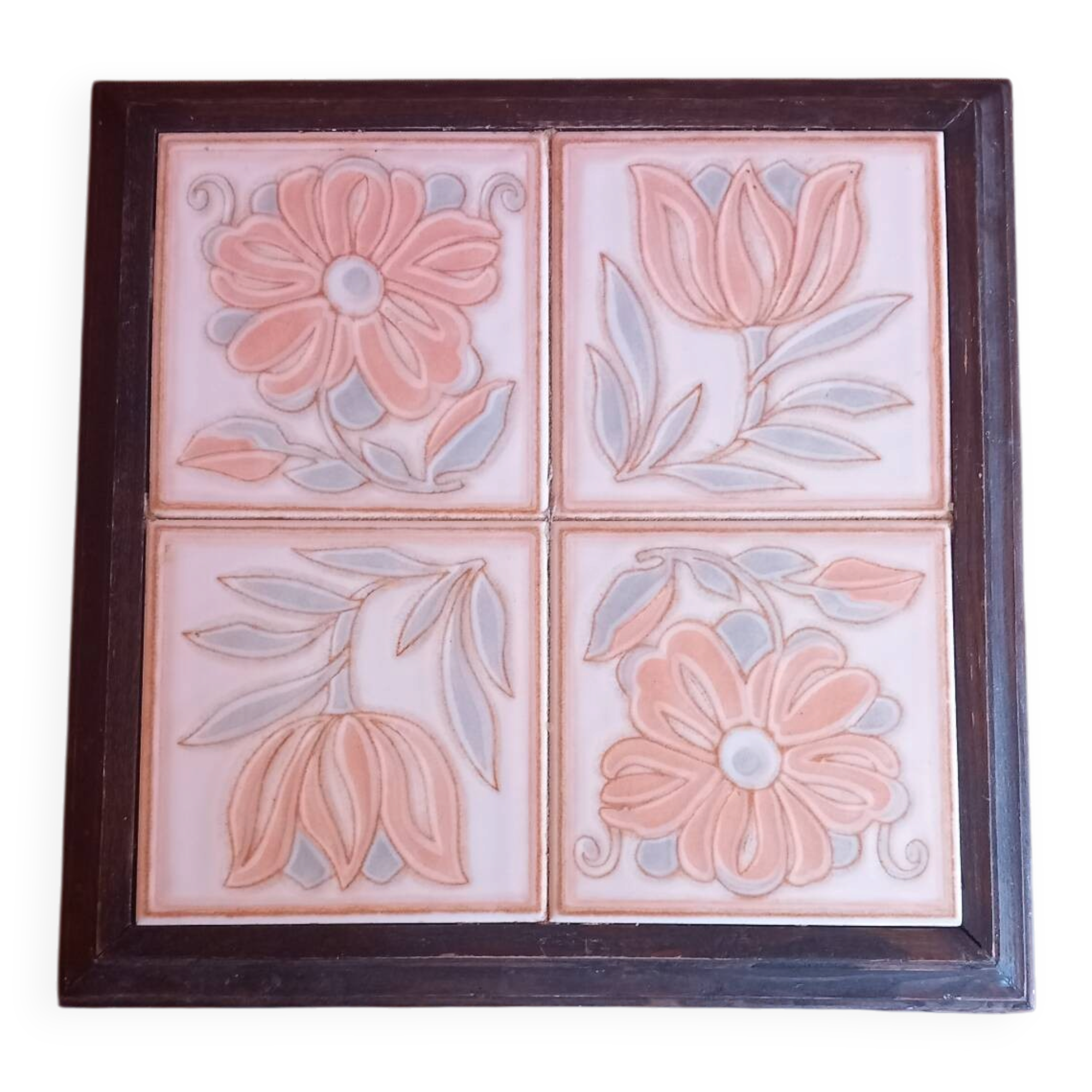 Ceramic tile trivet with floral patterns in pastel tones.