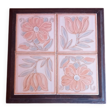 Ceramic tile trivet with floral patterns in pastel tones.